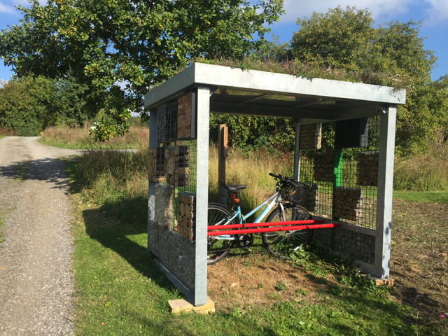 Side view with bicycle of a green roof bike stores